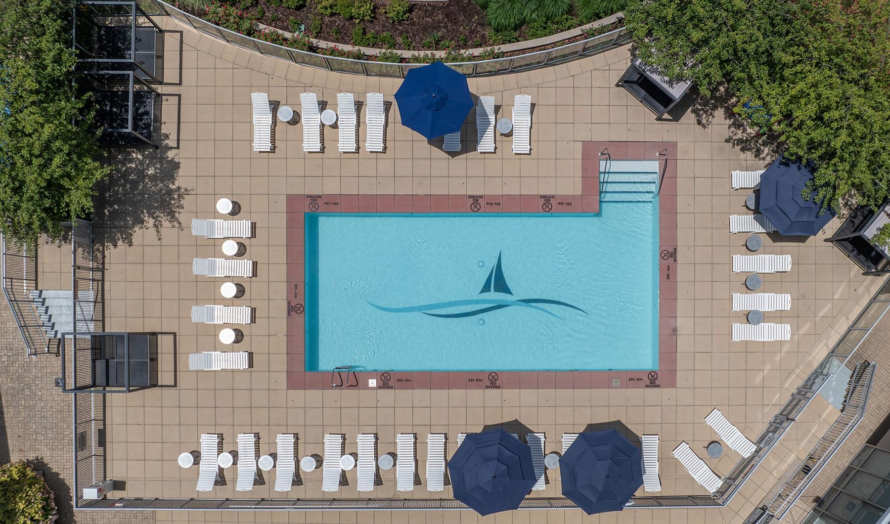 an aerial view of a pool with chairs