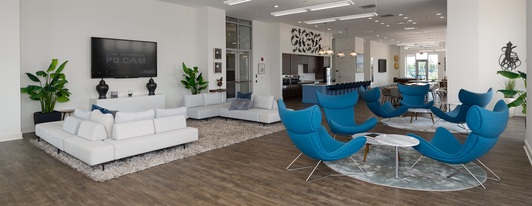 a clubroom with a tv, couch, tables and chairs